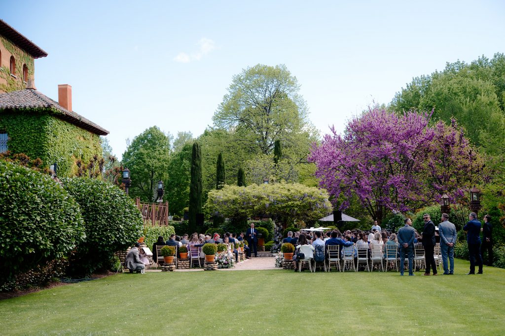 Vista interior del salón de banquete con vigas de madera oscura, mesas largas y redondas, y decoración de boda rústico-industrial en Madrid.